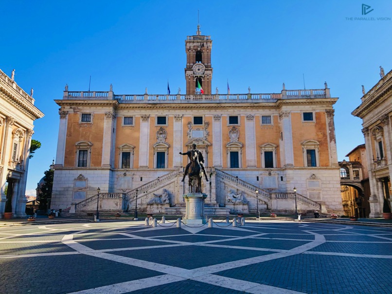 piazza-statua-edificio-orologio-cavallo-scale-bandiera-italiana